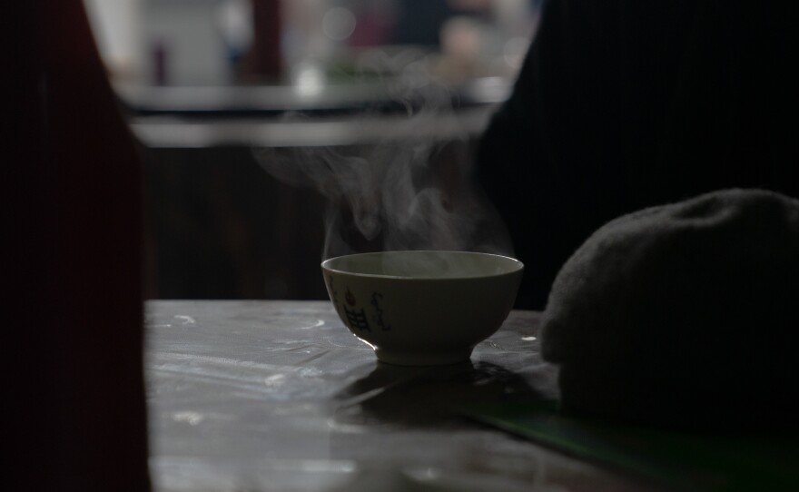 A customer enjoys a cup of hot milk tea at Batdelger Genden's restaurant in Tsagaan Khad.
