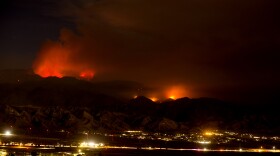 The Apple Fire burns behind mountains near Beaumont, Calif., Sunday, Aug. 2, 2020.