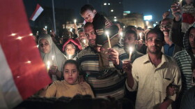 Anti-government protesters walk during a candlelight vigil for those killed during the uprising in Tahrir Square on February 9, 2011 in Cairo, Egypt. 
