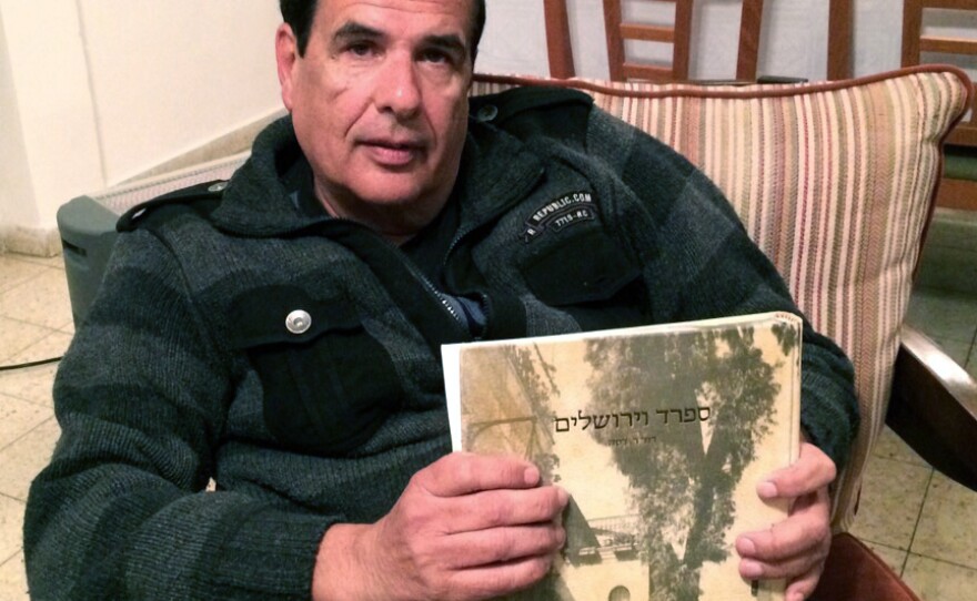 Itzhak Levy, seated in his Jerusalem apartment, holds a copy of a book on his family's history. Levy's ancestors were expelled from Spain. But he says he's not interested in the offer of Spanish citizenship because he doesn't feel that Europe today is supportive of Israel.