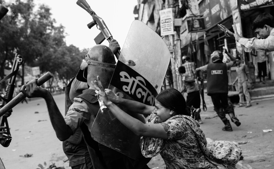 Rahela Akhter, a Bangladeshi garment worker, tries to resist beating from a police officer in riot gear during a protest in Dhaka, June 2010. Dozens of garment workers were injured in clashes with police when they took to the streets demanding higher wages.