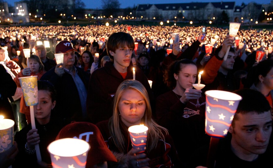 (Top) A candlelight vigil following the shootings on the Virginia Tech campus in Blacksburg, Va., on April 17, 2007. (Left) Blacksburg police officers run from Norris Hall on the Virginia Tech campus in Blacksburg on April 16, 2007. (Right) A Virginia Tech student stands by a cardboard "VT" that was part of a makeshift vigil placed on a drill field at Virginia Tech on April 17, 2007.