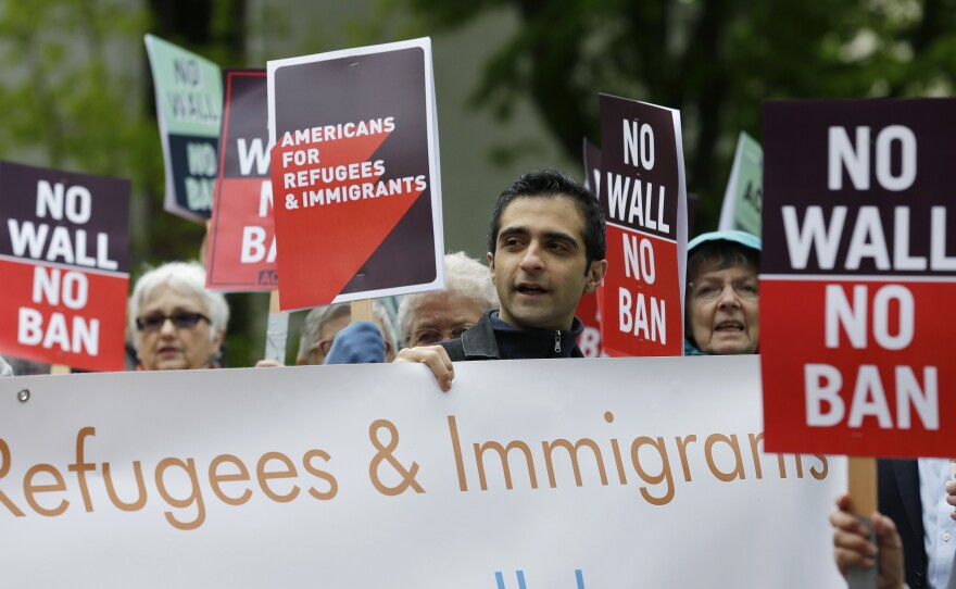 Protesters hold signs during a demonstration against President Donald Trump's revised travel ban, Monday, May 15, 2017, outside a federal courthouse in Seattle.