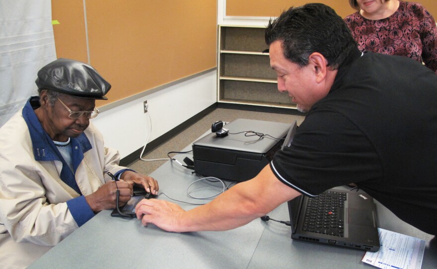 Adreanne Lewis signs up for a photo ID at a senior center in Arlington County, Va., with the help of Bill Sands, outreach coordinator for the county registrar.