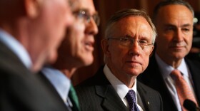 Senate Majority Leader Sen. Harry Reid (D-NV)(3rd L) and Sen. Charles Schumer (D-NY) (R) listen as Jim Guest (2nd L), president and CEO of the Consumers Union, speaks during a news conference October 21, 2009 on Capitol Hill in Washington, DC. 