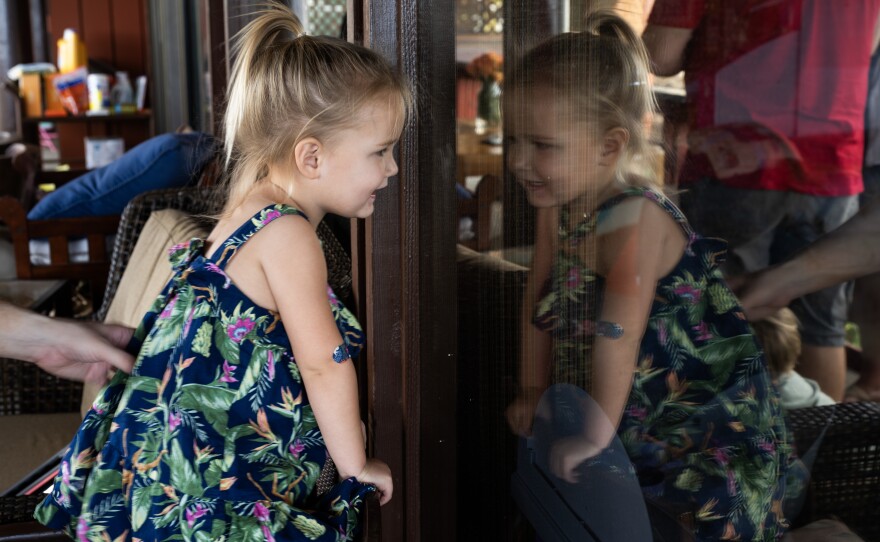 Ayla Souza plays on the wraparound porch of her family's temporary home. Her parents have tried to create some stability here after their life in Lahaina was completely disrupted by the wildfires.