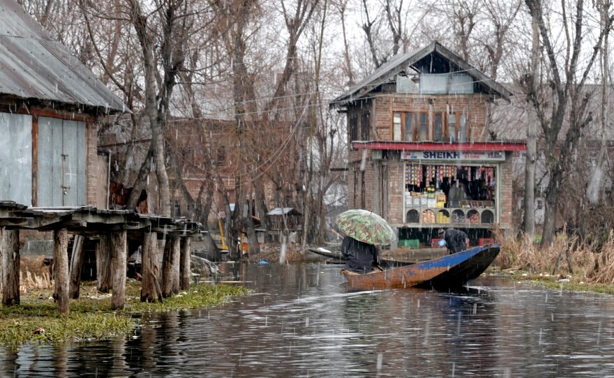 A vendor heads home from Dal Lake's floating wholesale produce market during an early February snowstorm.