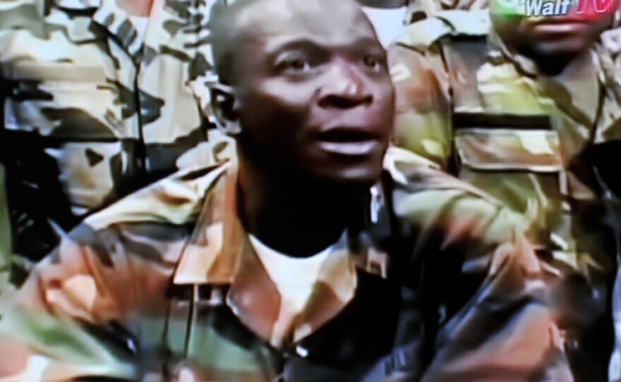 The leader of the junta that seized power in Mali, Army Capt. Amadou Sanogo, announces a curfew in the capital, Bamako, on Thursday, in this photo taken from television.The coup ousted an elected president who was due to step down after a new election next month in the West African nation.
