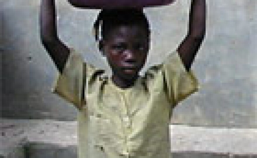 A girl hauls water in an open basin in the Congolese town of Kibombo.