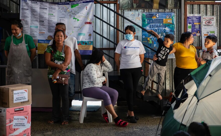 Migrants wait to receive toiletry items at Moviemiento Juventud 2000 in Tijuana on July 26, 2023.