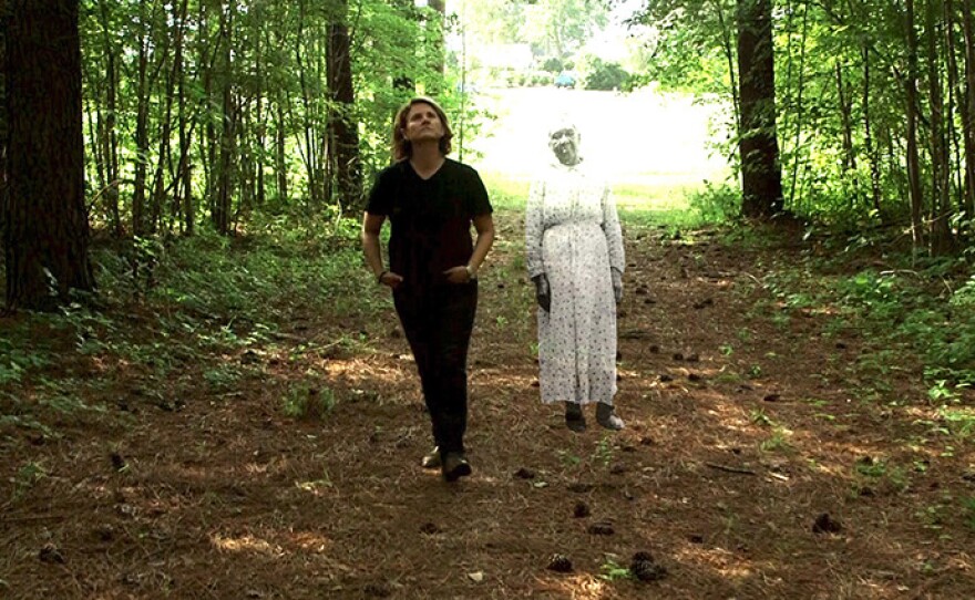 Filmmaker Frances Causey walking with a ghost-like woman figure next to her.