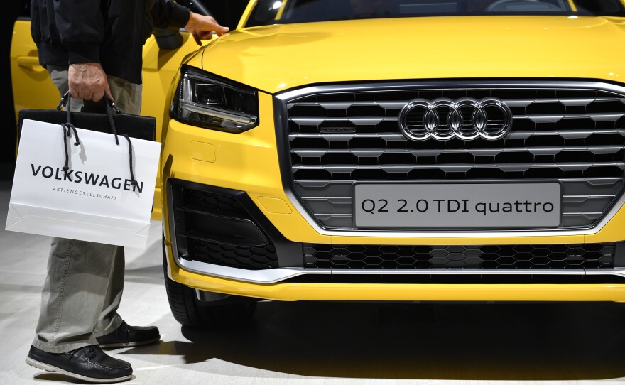 Owners of vehicles with larger VW diesel engines that have emissions-cheating software could get their cars fixed or bought back, the company says. Here, a man walks by an Audi diesel at company meetings last summer.