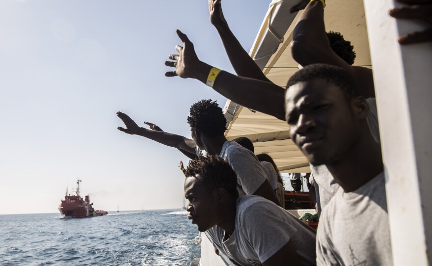 Migrants aboard the Open Arms aid boat, run by Spanish humanitarian group Proactiva Open Arms, react as the ship approaches the port of Barcelona, Spain, on July 4. The aid boat sailed to Spain with 60 migrants rescued in waters near Libya, after it was turned away by both Italy and Malta.