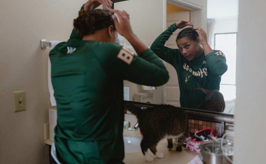 Sabrina Robinson, the Boston Hunters' first baseman, fixes her hair in her hotel room before going out with her fellow players in the Women's Pro Baseball League on Thursday, July 30.