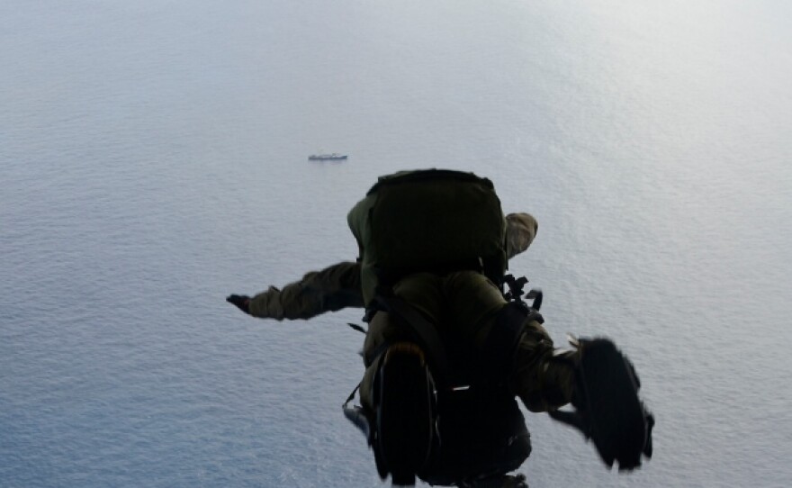 A U.S. Air Force pararescue airman from the 48th Rescue Squadron parachutes into the Pacific Ocean to aid to two critically injured sailors May 3, 2014.
