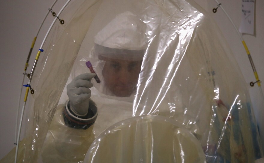 Microbiologist Lt. Jimmy Regeimbal prepares a blood sample to test it for Ebola at the U.S. Navy mobile laboratory in Gbarnga, Liberia, last October. To run the new rapid test, a health worker wouldn't need to wear full protective gear but would still need some special equipment.