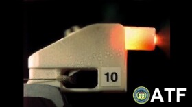An all-plastic gun fires a bullet in this screenshot from a video made by the Bureau of Alcohol, Tobacco, Firearms and Explosives.