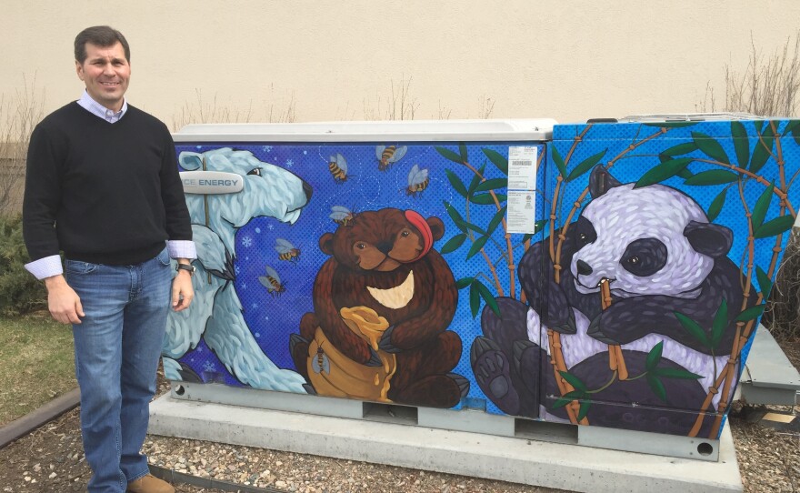 Greg Miller, executive vice president of Ice Energy, poses next to the "Ice Bear," his company's invention. The equipment cools down air conditioners in the day and stores energy at night.