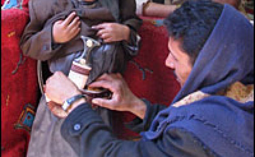 Naif Mohammed straps a jambiya dagger for the first time onto his 7-year-old son, Bashir. For centuries, these knives have been a symbol of manliness and social status in Yemen.