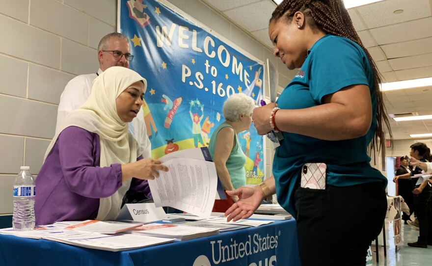 Census Bureau partnership specialist Zakera Ahmed (left) and Jeff Behler, a regional director with the bureau, share information about the 2020 census at an elementary school in Corona, N.Y., in July.
