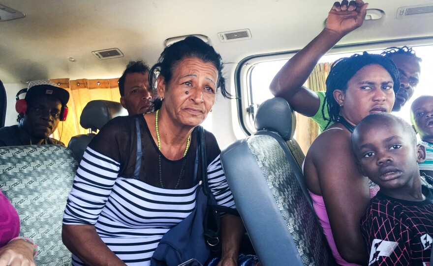 Marta sits in a van with migrants from Haiti after being detained by Peruvian migration officials. When the head officer took a liking to Liset, he decided to let them go and released the group.