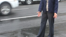 SDSU Professor Sherry Ryan poses over an electronic loop, embedded in the street, that keeps track of the number of bikes which travel on that route. 