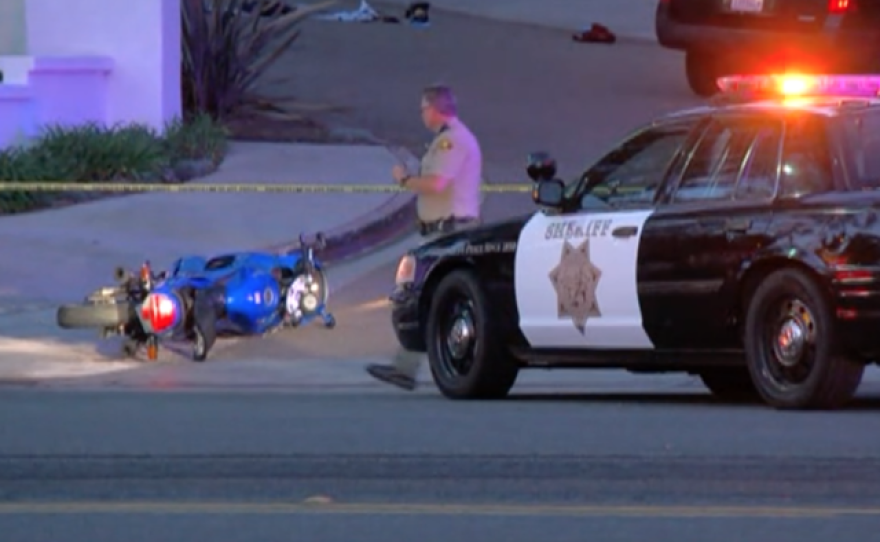 A San Diego County Sheriff's deputy stands next to a wrecked motorcycle that a suspect was using to flee a robbery in Encinitas, Nov. 14, 2016.