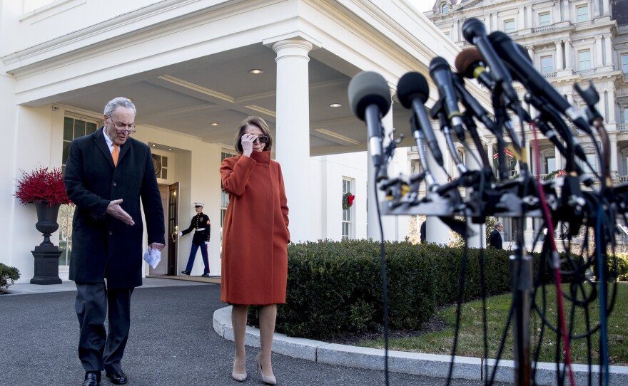 Democratic House leader Nancy Pelosi and Senate Minority Leader Chuck Schumer approach microphones outside the White House after a contentious meeting with President Trump.