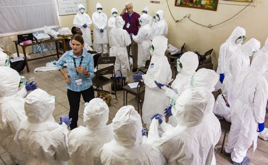 A World Health Organization worker trains nurses how to use Ebola protective gear in Freetown, Sierra Leone, Sept. 23, 2014.