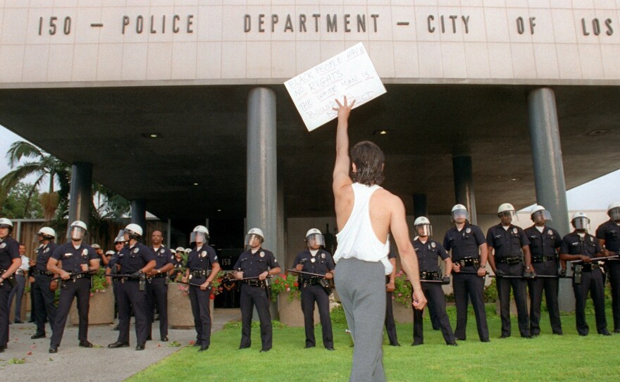 A demonstrator protests the verdict in the trial of four Los Angeles police officers accused of beating motorist Rodney King outside the Los Angeles Police Department headquarters on April 29, 1992. Riots broke out in Los Angeles after a jury acquitted the four police officers accused of beating King.