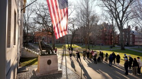 FILE - People take photos near a John Harvard statue, left, on the Harvard University campus, Jan. 2, 2024, in Cambridge, Mass.