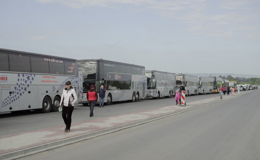 Buses line up to take Ukrainians back over the border and home.