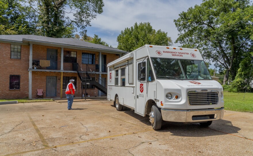 Andrew Jennings, a Salvation Army employee, signals the driver of a truck filled with water for distribution into the parking lot of an apartment complex in Jackson.