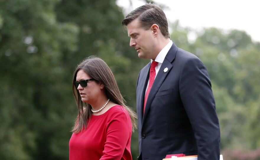 White House press secretary Sarah Huckabee Sanders with then-staff secretary Rob Porter in August. In the wake of Porter's resignation, Sanders has reassured reporters that President Trump is sympathetic to victims of domestic abuse.