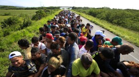 Hundreds of migrants hitch a ride in a truck between Niltepec and Juchitan, Mexico, Tuesday, Oct. 30, 2018. 