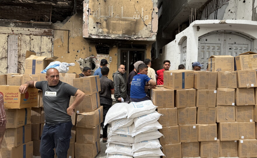 Palestinians stand next to boxes of U.N. food aid in an area that aid groups need Israeli permission to enter in Jabalia, Gaza, on April 18, 2026.