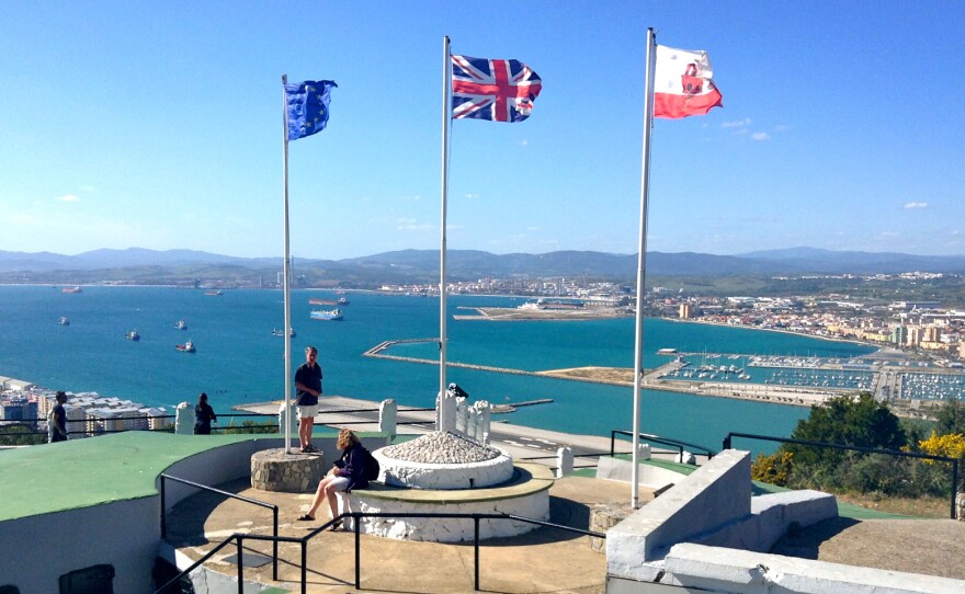 Flags of the European Union, Great Britain and Gibraltar (left ot right) fly over a former military post in Gibraltar.