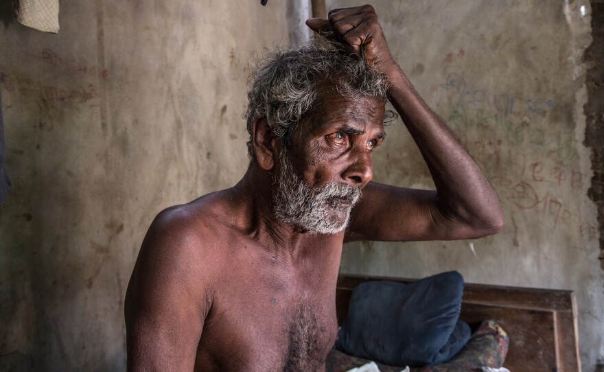 "They dragged him away like this," the father of Nagulesan Naguraja says while  demonstrating how the military took his son away.