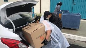 Two students load up a car outside the Zura Residence Hall at San Diego State University, March 18, 2020.