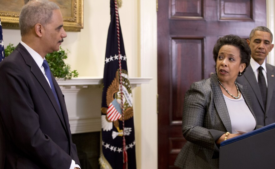 U.S. Attorney General nominee Loretta Lynch, center, looks to outgoing Attorney General Eric Holder as President Obama stands nearby Nov. 8 in the Roosevelt Room of the White House.