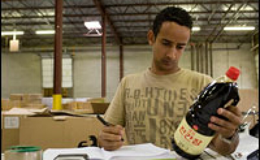 Nebil Oumer, consumer safety officer for the FDA, inspects a bottle of soy sauce at a warehouse in Baltimore, Md.