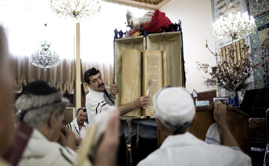 Iranian Jewish men read from the Torah scroll during morning prayers at Youssef Abad synagogue in Tehran in 2013.