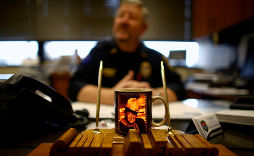A coffee cup featuring John Wayne sits on the desk of Sidney's police chief, Frank Difonzo. He's been the police chief since the last oil boom in the early 1980s. His caseload is enormous; crime is up tenfold and he's constantly playing catch up.