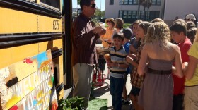 Dana Middle School Teacher Scott Schwerdtfeger corrals students waiting to tour the bus San Diego Unified is hoping to turning to a full-fledged mobile farm, Oct. 13, 2011.