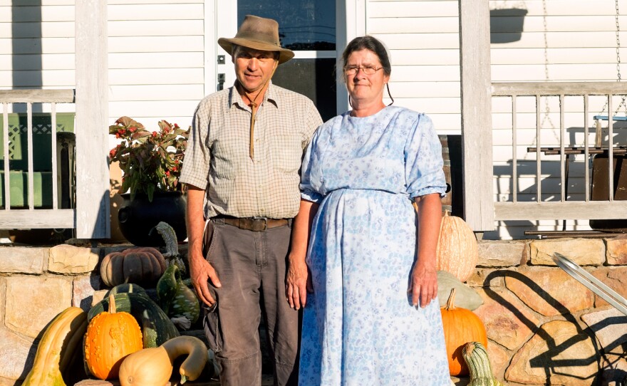 Charles Martin and his wife, Rosa, stand amidst some of their favorite gourds and squash from this year's harvest.