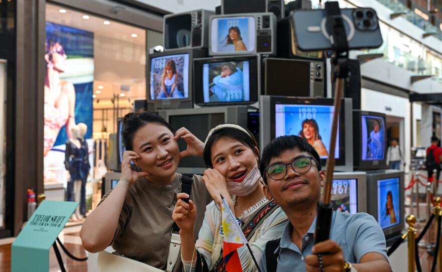 Fans of singer Taylor Swift take pictures next to an installation in the "Eras Tour Trail" that depicts different eras of the pop star's career, at the Marina Bay Sands complex in Singapore, on Feb. 28. More than 300,000 Swifties from Singapore and neighboring countries will attend the U.S. superstar's six sold-out Eras Tour shows at the National Stadium from March 2-9.