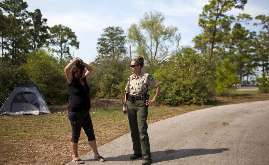 Susan Arawley (left) speaks with Jamie Creacy, superintendent of the Lost Pines Complex, which includes Bastrop State Park. As Hurricane Harvey hit, Arawley tried picking up supplies and got stuck in rising flood water. After sleeping in her car four nights, she decided to head to Bastrop State Park, where she could take a shower.