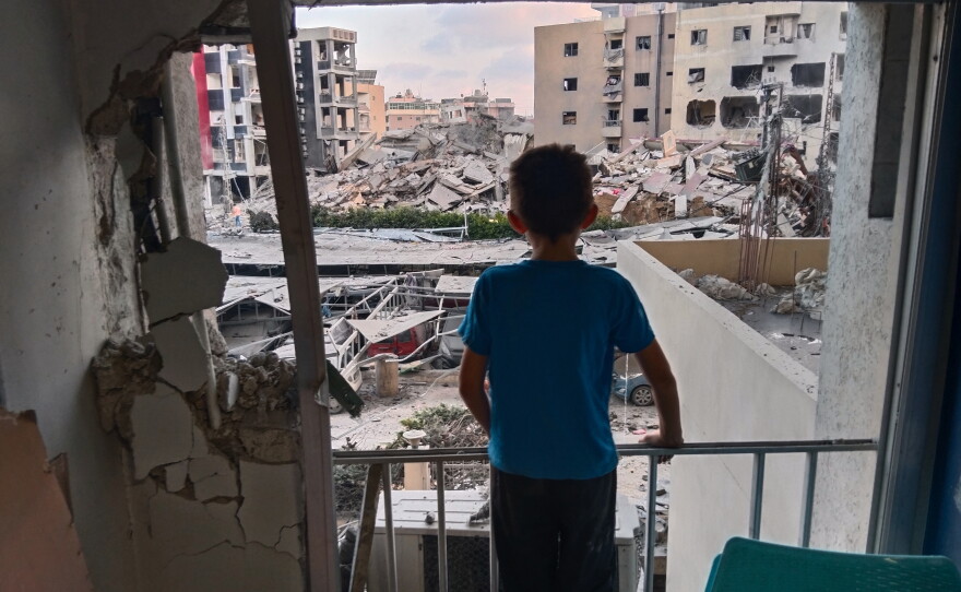 A boy looks through a damaged room of the Jabal Amel Hospital into a destroyed building that was hit in an Israeli airstrike in the southern port city of Tyre, Lebanon, June 1, 2026.