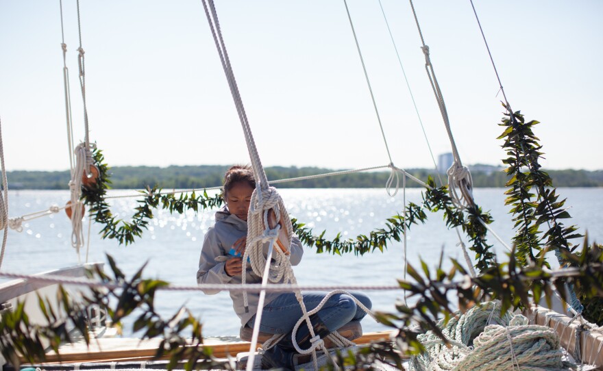 Kala Tanaka marks "stays" at the front of the canoe so they can go back in the same place after the mast is taken down to fit under the George Washington Bridge. The garlands of ti leaves, a Hawaiian tradition, were placed on the Hokule'a by well-wishers.
