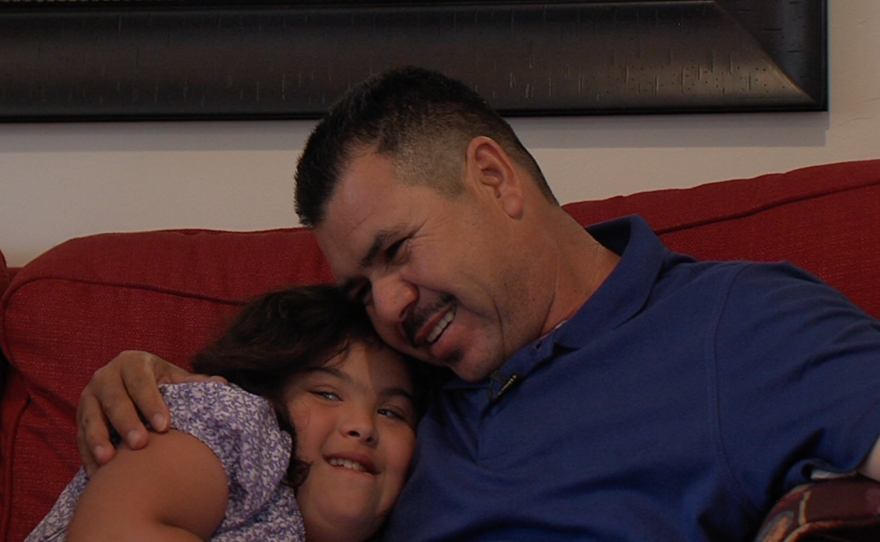 Enrique Cervantes hugs his youngest daughter, who has Down Syndrome, June 12, 2015.